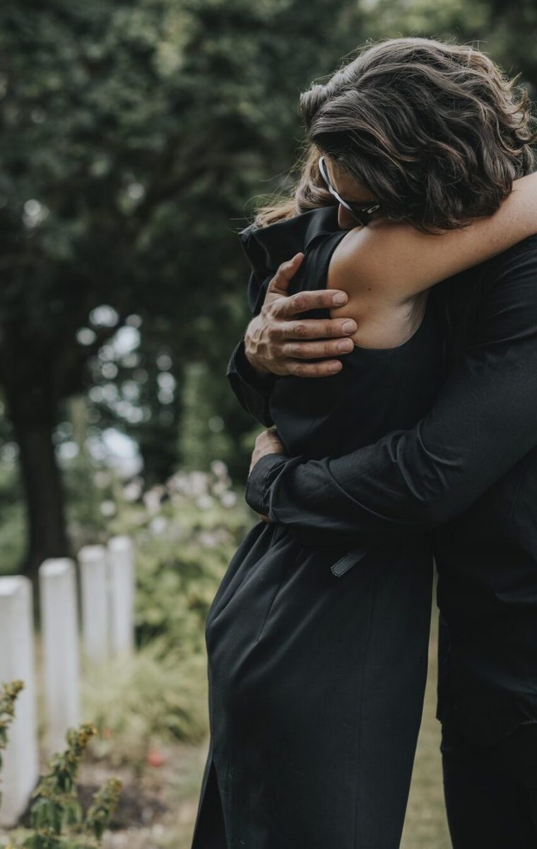 husband-trying-to-comfort-his-wife-at-a-graveyard.jpg husband-trying-to-comfort-his-wife-at-a-graveyard.jpg